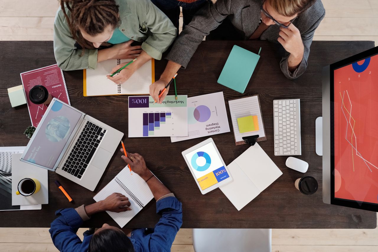gallery-04 Overhead view of a diverse team collaborating on a project in a modern office setting.